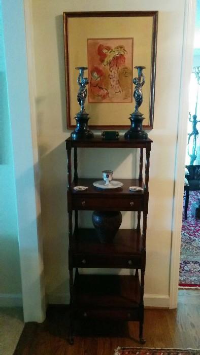 Original watercolor of a nameless angel and Madonna, overlording a repro mahogany shelf, with drawers. There's also a pair of very good antique silver plated putti candlesticks, with black marble bases. 