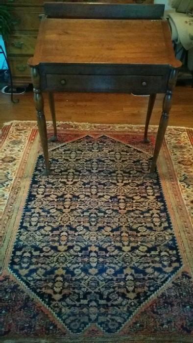 Antique slant-topped desk, atop a well-aged persian Bidjar. 