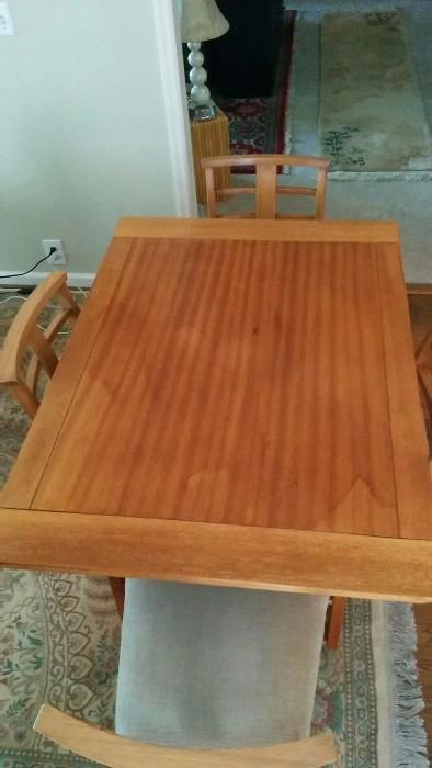 Very cool MCM table w/4 chairs. Made by the Showers Brothers company in Bloomington, IN (1884-1958). This table has two leaves, all in excellent ribbon mahogany wood. They produced furniture and coffins.                    Seriously, Google away if you're in doubt...