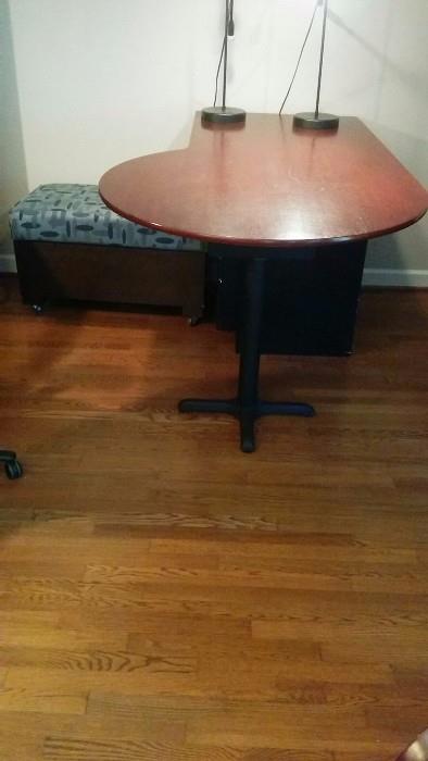 Kidney shaped desk, with storage unit trying to hide underneath, but we can still see it.