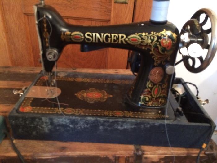 Antique working Singer Sewing machine with work light. Decorated with delightful designs in gold,red and black. Has carrying case which shows wear and tear, but locks securely for carrying. $175.