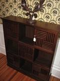 A good-looking "zen" style cabinet with sliding slatted doors from Pier 1 with a heavy iron wreath sculpture on top.