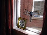 Two stained glass pieces - a dragonfly and green and gold symbol piece.