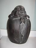 Earthenware laughing Buddha with prayer beads.