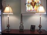 A pair of column lamps with faceted bead trim on shades.  A wire-work decorative tower and frame.