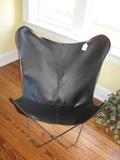 One of a pair of folding sling chairs with black leather covers.