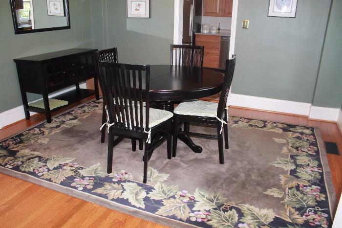 Dining room table and 4 chairs, black sideboard, and area rug