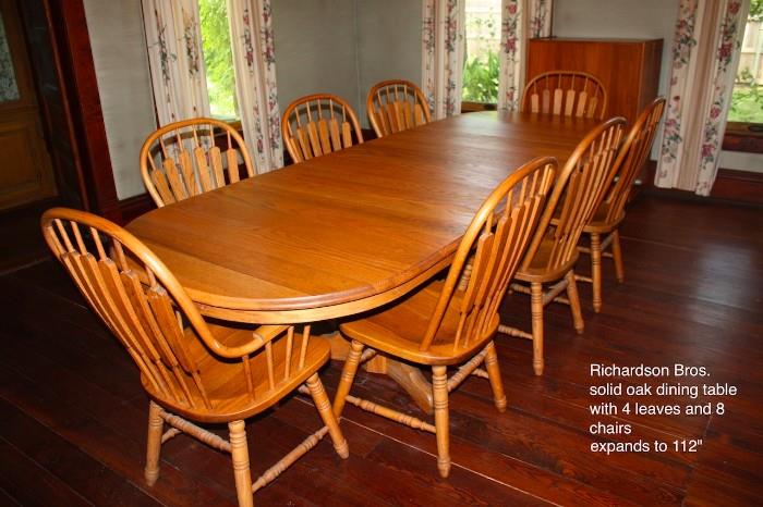 Richardson Brothers dining table with eight chairs. solid oak. four leafs. extends to 112 inches in length