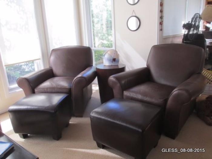 Leather Club Chairs and Leather Ottomans, Congo Style End Table, Ceramic Vase and Round mirrors on Wall.