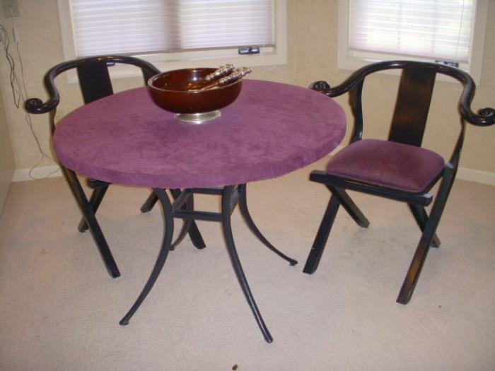 Metal (heavy, but not iron....magnet doesn't stick).  Round table & 2 chairs.  It looks like the chairs might fold, but they do not.