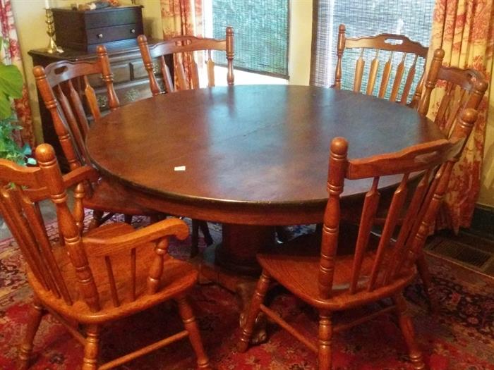 American oak round dining table with carved paw feet.  Set of six attractive chairs, not matching table.