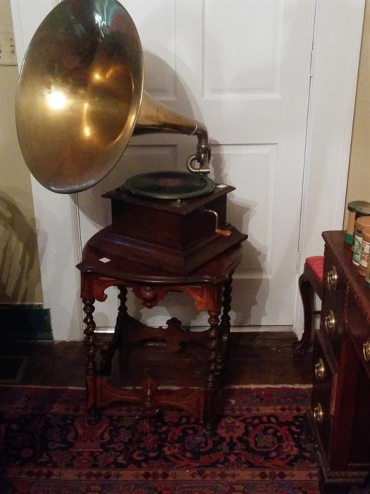 Very good antique victrola with brass horn, in working order with an original record.