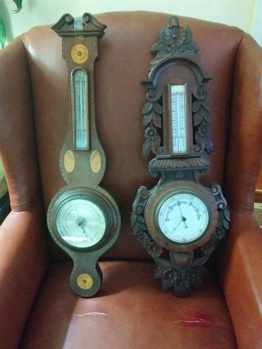 Two handsome old barometers, one inlaid mahogany and the other richly carved. 