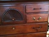 Detail of New England tall chest showing hand carved shell and on brass bail pull