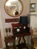 Clockwise from top: round mirror, Pillar and scroll game table with butterfly top, 1930's nesting tables, tole lamp of good brass, various mantle clocks, tole lamp and moon phase sculpture