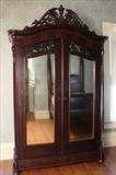65 - Mahogany rococo 2 door wardrobe with heavy carving on crown and mirrored doors, 104 in. T, 64 in. W, 22 in. D.
