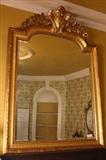 129 - Gold leaf over the mantle mirror with beveled glass and ornate crown, 69 x 47.
