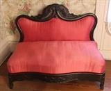 130 - Mahogany bustle bench with carved crown and pink upholstery, ca. 1850, 33 in. T, 40 in. W, 18 in. D.
