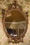 205 - 19th Century oval beveled mirror in ornate gilded frame, 47 x 31
