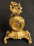 295 - Metal French gold gilded clock with cupids on top, 9 in. T, 6.5 in. W.
