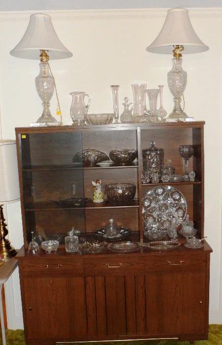 Vintage china cabinet with assortment of crystal pieces.