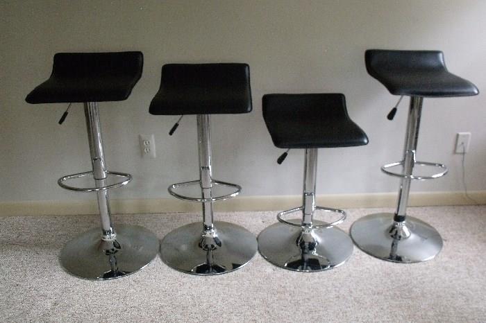 4 bar stools. Chrome with black leather seats. All chairs have adjustable height.
