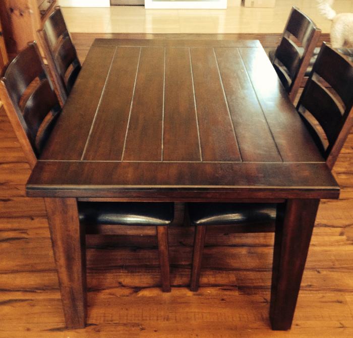 Cherry Wood Dining Table with Four Chairs. Chairs have a black leather seat.