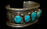 Lot 27: Navajo sterling old pawn 5 stone turquoise cuff  having
heavily stamped borders and applied sterling feathers to both
sides, one stable natural hairline to one stone, c.1940-1950
est. $150.00-$250.00
