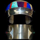Lot 31: F. C. Carillo inlaid lady's cuff with 13 gemstones to include
turquoise, lapis, mother of pearl, coral and sugilite in a tapered
cuff measuring 1.56" wide, artist signed, est. $150.00-$300.00
