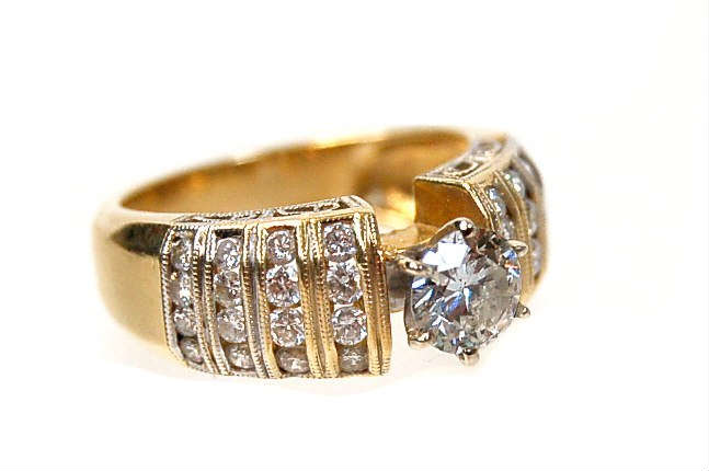 Lot 107: 18K diamond ring set with a round, brilliant cut diamond approx.
0.95 carats, SI clarity I-J colour, accented with 32 round diamonds approx.
weighing 0.75 carats, approx. 1.70 carats TDW weighing 7.6 grams
est. $2,500.00-$3,000.00