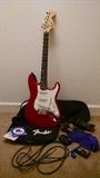 Fender electric guitar with strings, case, and accessories