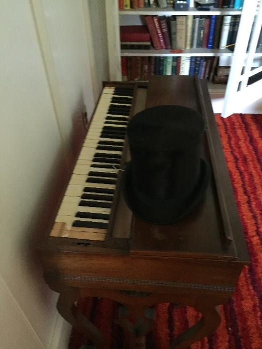 Spinet piano and vintage top hat 