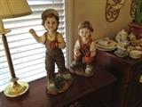 2 cast statues of boys playing baseball