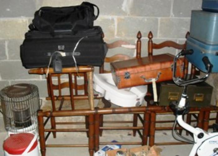 Another view of suitcases, chairs, portable heater, exercise bike, etc. in basement