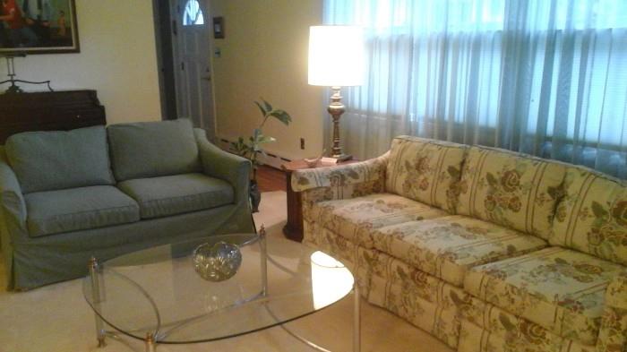 Glass/chrome table, floral 3-seated couch (W.J. Sloane), slip -covered 2-seat floral couch, lamp and lamp table.