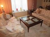 Pair of Loveseats, End Tables, Lamps, Coffee Table with Beveled Glass, Doilies (on Couch)