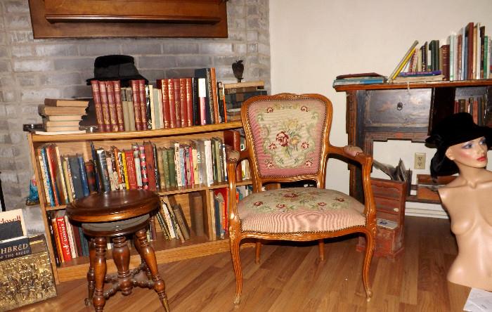 Antique needlepoint chair. Antique claw foot piano stool. Some of the books...