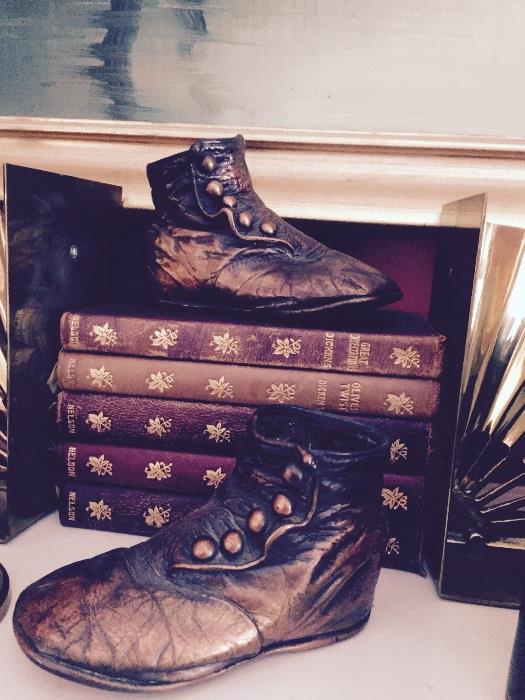 Antique bronzed baby shoes and a set of small leather bound books