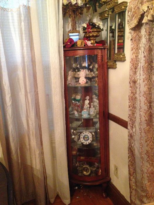 Curio cabinet full of interesting things, and a trio of mirrors.