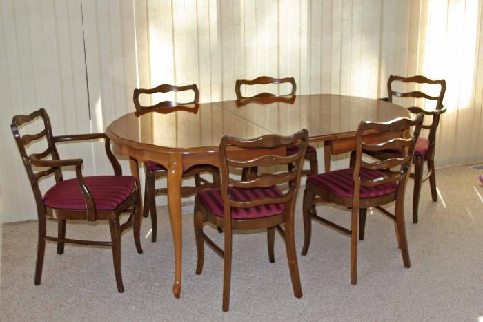 Solid wood oval dining table with four straight chairs and two armed chairs. Table pad & table cloth included. Approximate dimensions: 68"L x 42"W x 29"H.