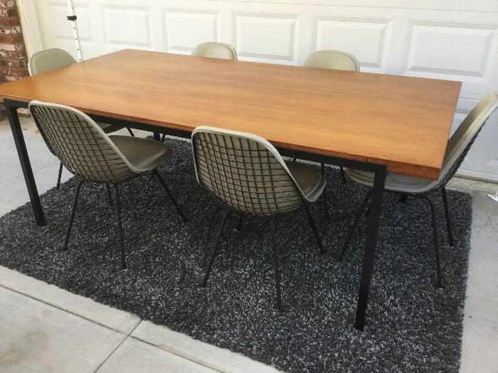 STYLE OF MILO BAUGHMAN IRON/WALNUT TABLE WITH SIX VINTAGE EAMES WIRE CHAIRS