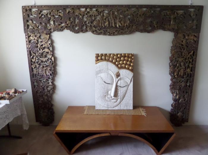 GREAT MID CENTURY TABLE ,FRAMED BY LARGE ASIAN TEMPLE FRET WORK. AND LARGE WOOD CARVED  FACE