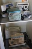 Three sewing machines and other sewing items.