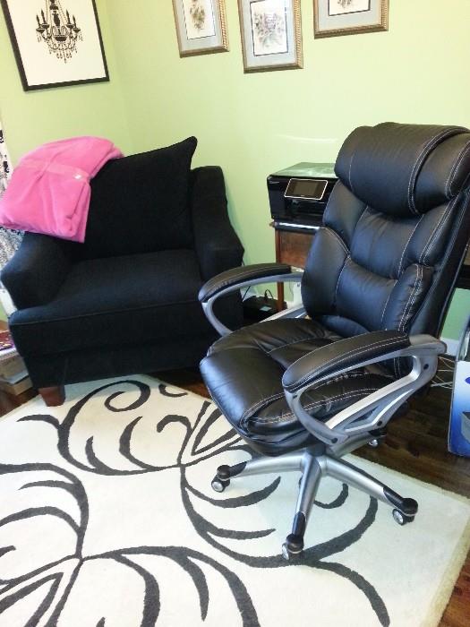 Really comfortable black chair. Would be great in a salon. black leather office chair. Area rug, HP printer, and a small table