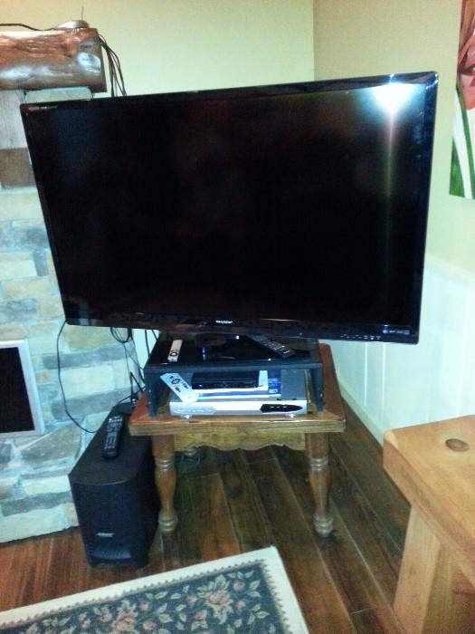 52inch Sharp Aquos Quattron (HD) Television, a set of Bose speakers, and a dvd player