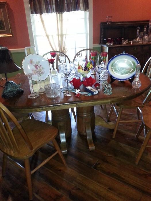 Double pedestal oak dining room table and lovely pieces of china and crystal, very decorative wine stoppers, beautiful platters, etc.