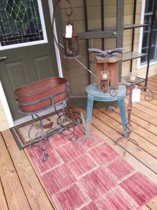 copper planter with a wrought iron base, wrought iron base with a lantern, iron 3 lite candle stand, several small tables and yard art