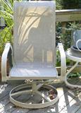 One of a pair of outdoor chairs, partial view of matching small table.