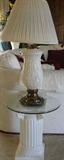 One of a pair of glass top end tables and lamps.