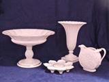 Grouping of classic ivory Lenox porcelain, including large pedestal base fluted fruit or centerpiece bowl, a low floriform candle holder for a grouping of tapers, a fluted vase on a square base-great to show off some autumn leaves or holiday greenery, and a small disc form pitcher with heavy molded relief design.